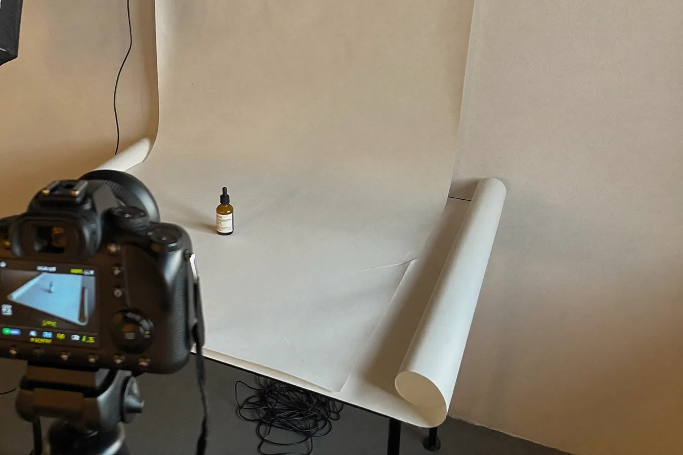 Productfotografie-opstelling met papieren achtergrond en camera op statief